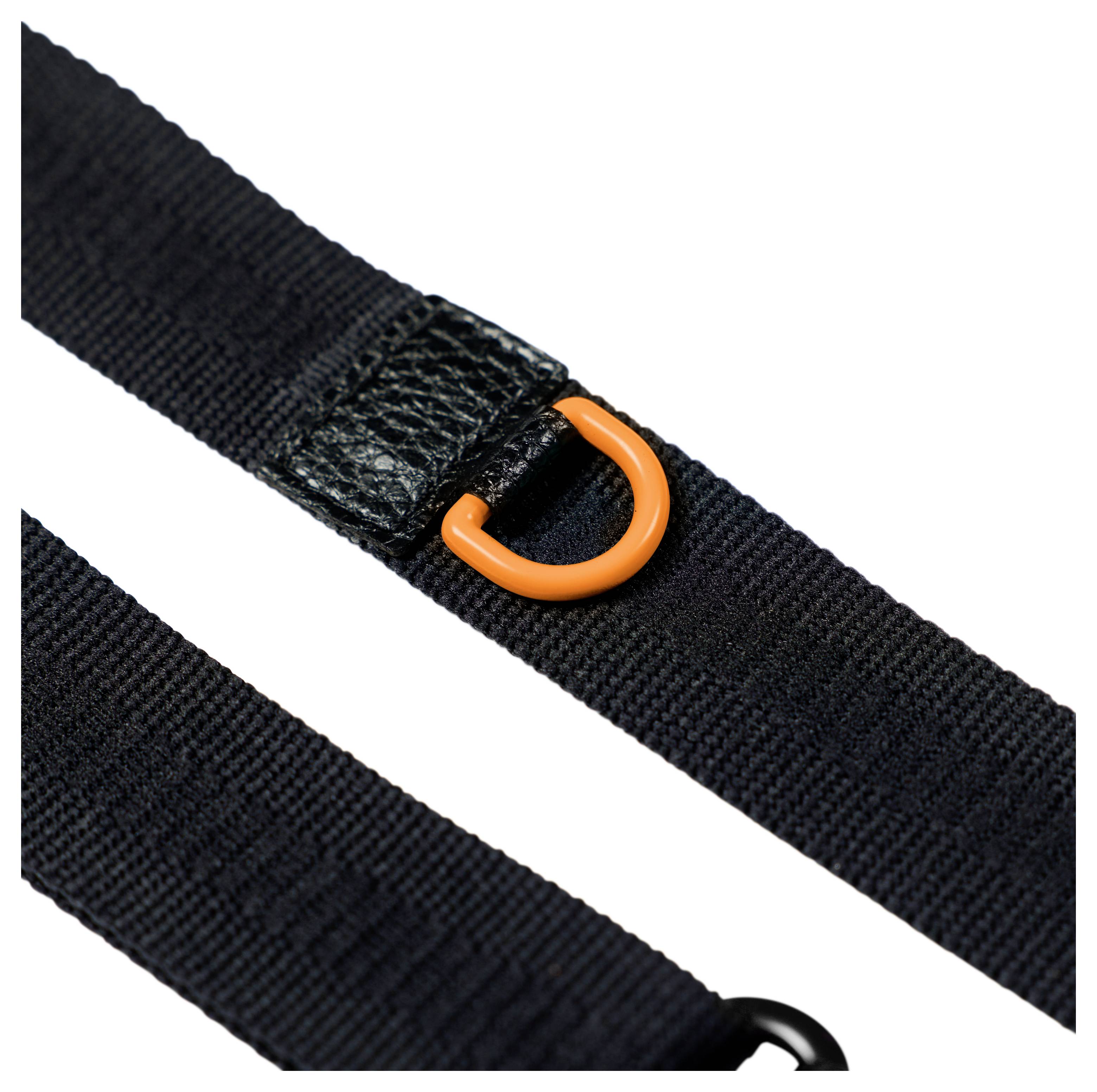 Close-up van zwarte nylon riemen met een oranje D-ring gesp op een witte achtergrond.