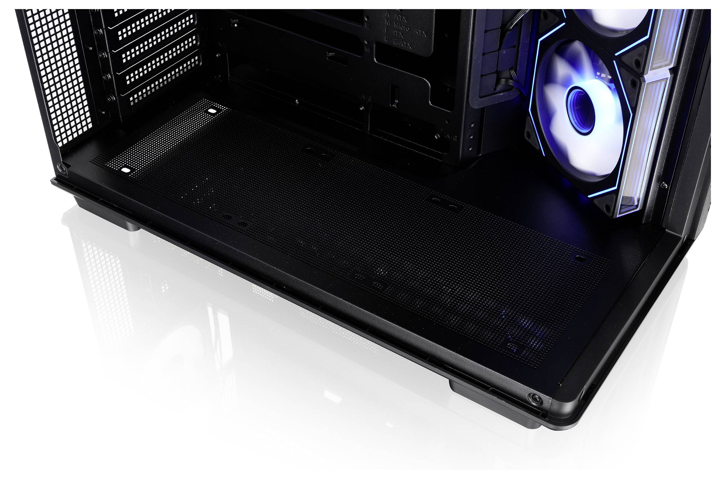 Binnenkant van een desktop-pc-behuizing met een grote zwarte PSU-afscherming en een blauw verlichte koelventilator aan de rechterkant.