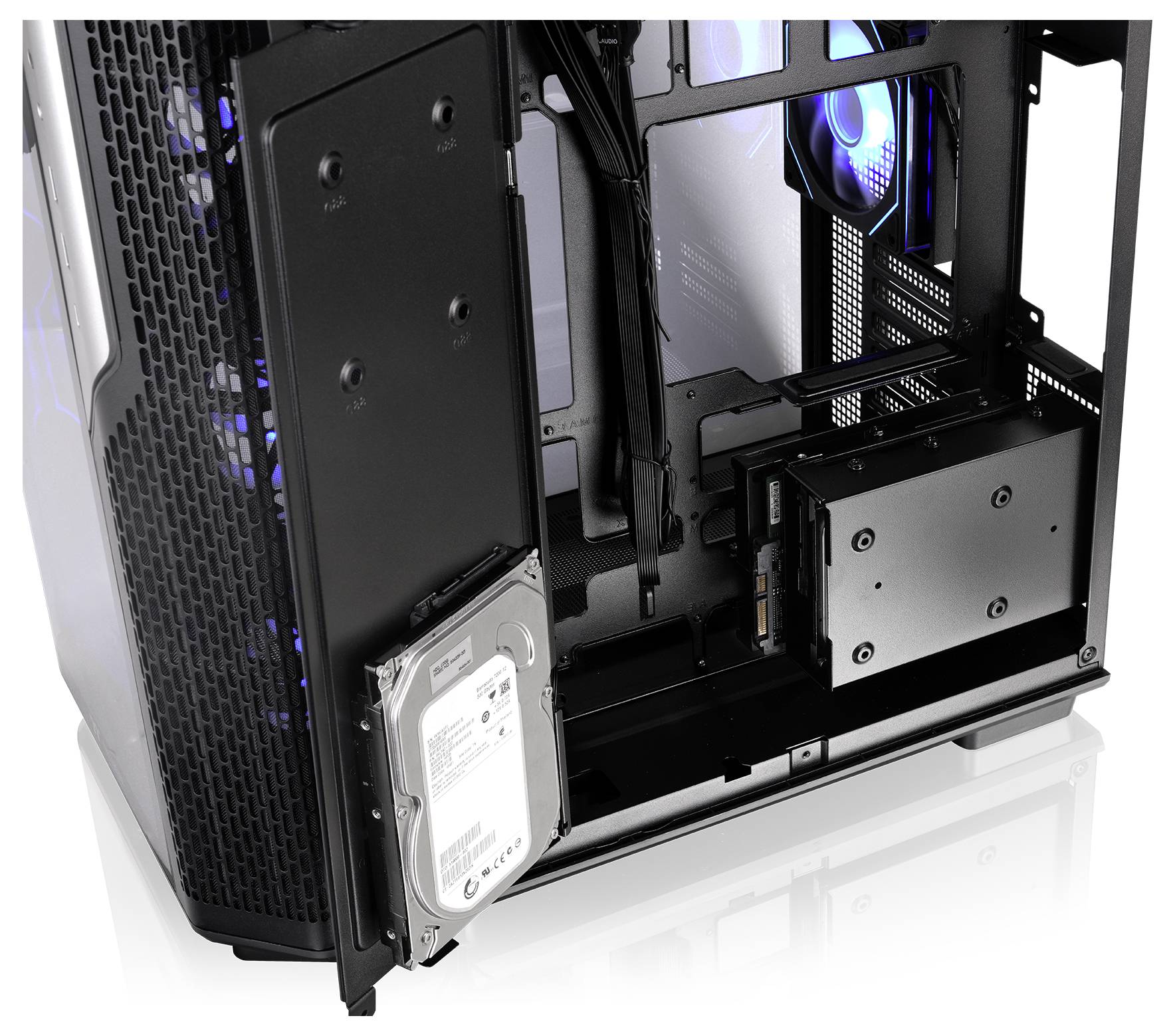 Open PC-behuizing interieur met interne componenten, inclusief een harde schijf gemonteerd aan de onderkant vooraan en blauw verlichte koelventilatoren.