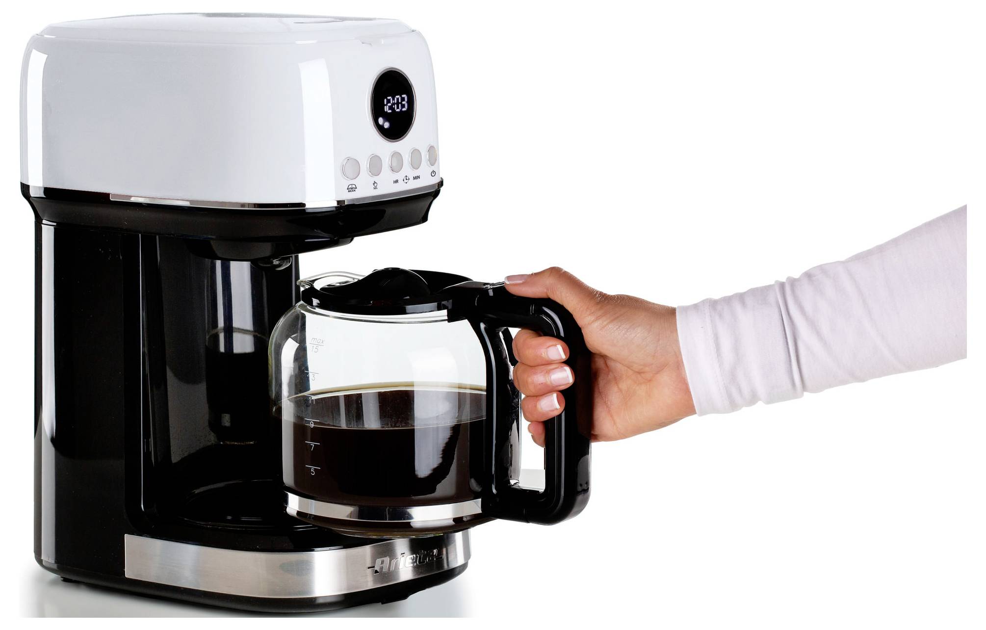 Hand die een glazen koffiekan in een druppelkoffiemachine plaatst met verse koffie erin op een witte achtergrond.