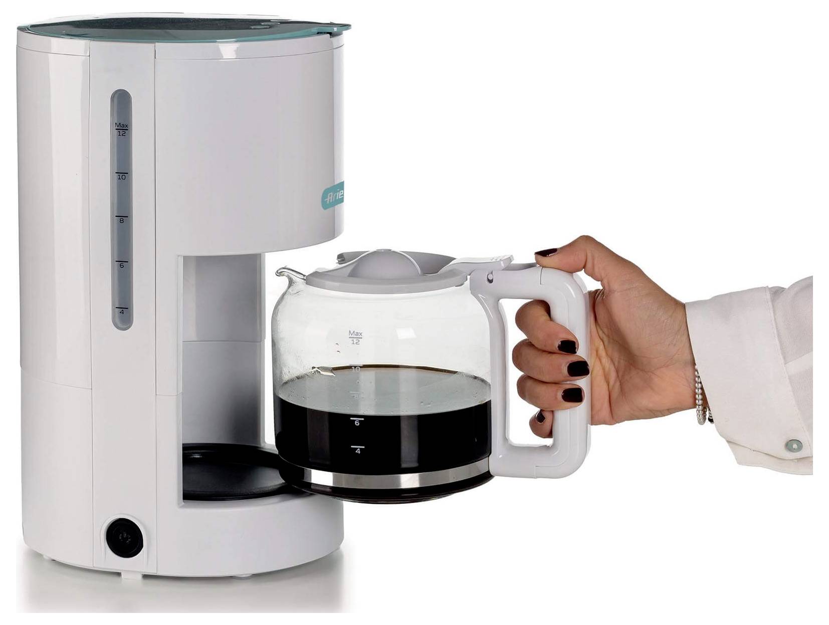 Hand die een glazen koffiepot onder een druppelkoffiezetapparaat plaatst, met gezette koffie zichtbaar in de karaf.