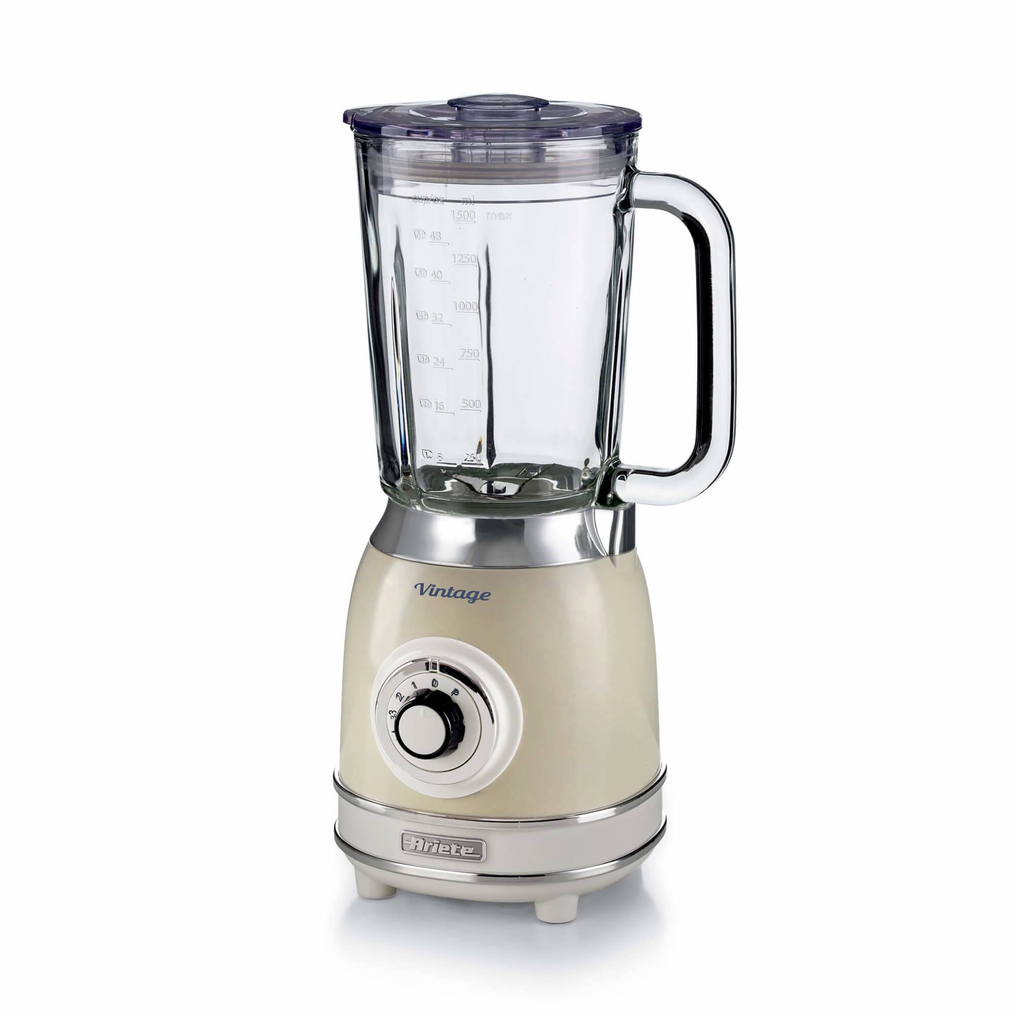 Een beige aanrechtblender met een helder glazen kan, deksel, handvat en voorste bedieningsknop op een witte achtergrond.
