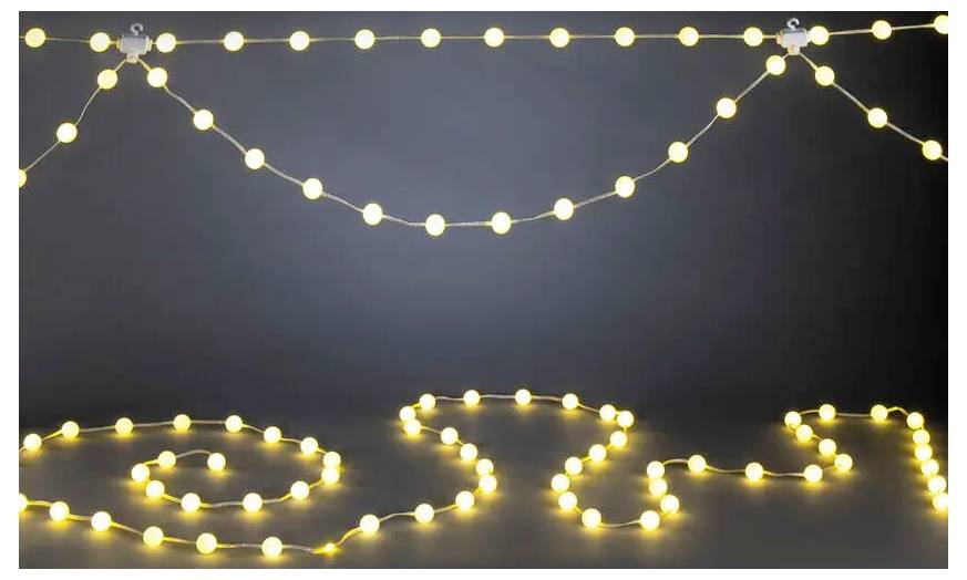 Warme slingerlampen die in lussen zijn gerangschikt, spellen 'OPEN' op een donkere achtergrond, met extra hangende lampen erbovenaan.