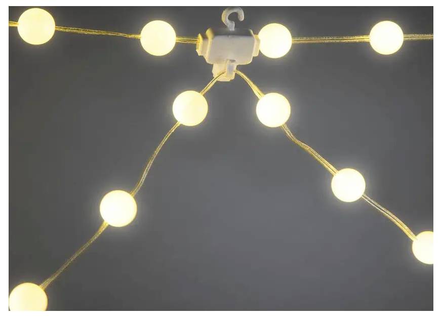 Een hangende snoer van gloeiende ronde lampen in een vertakkend patroon tegen een donkere achtergrond.