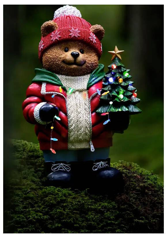 Een teddybeer-figuurtje in een rode winterjas en muts houdt een klein versierde kerstboom vast met lampjes en een ster op de top.