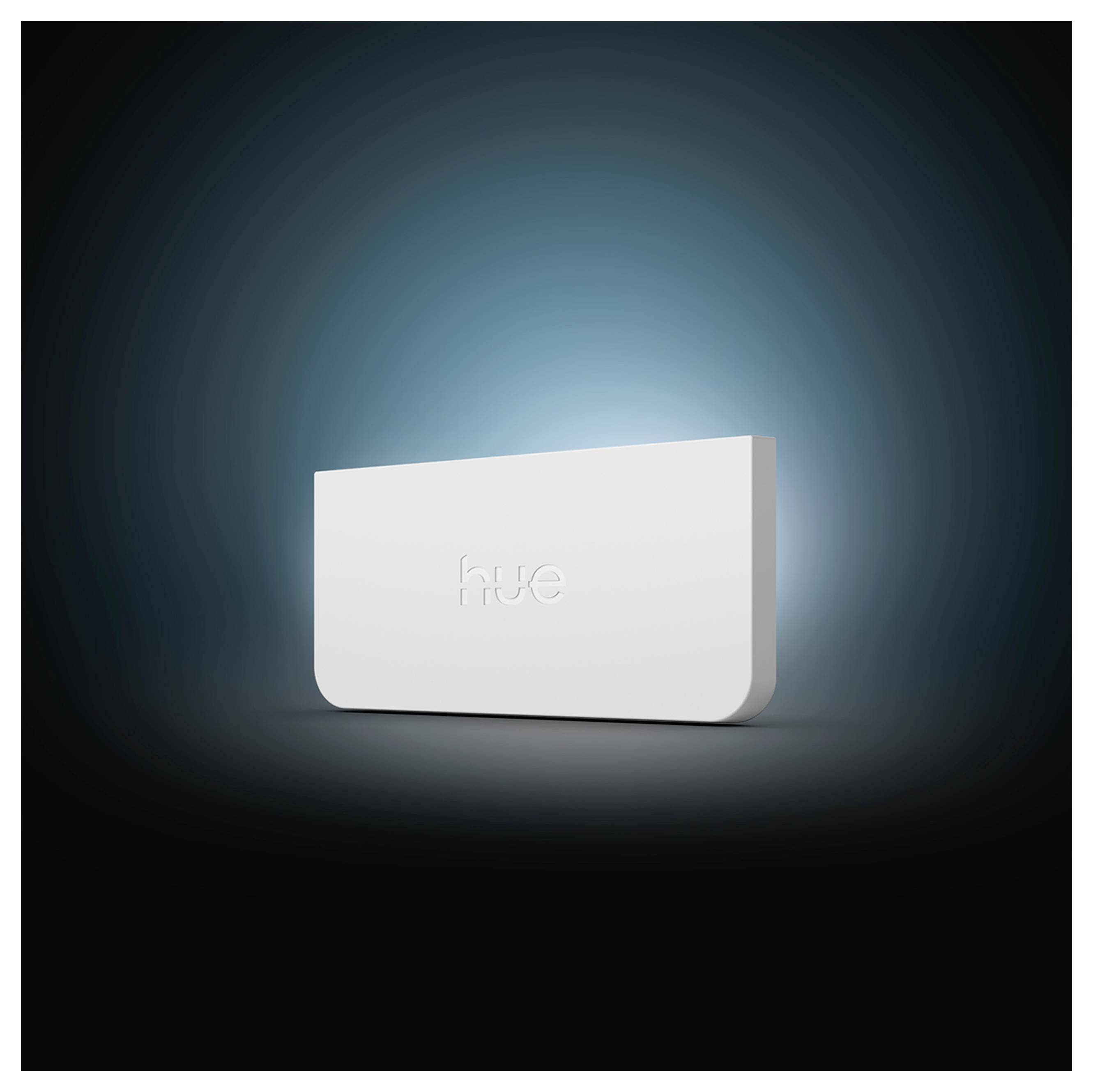 Witte Philips Hue intelligente verlichtingshub met een gloeiendo blauwe achtergrond op een donkere verloopachtergrond.