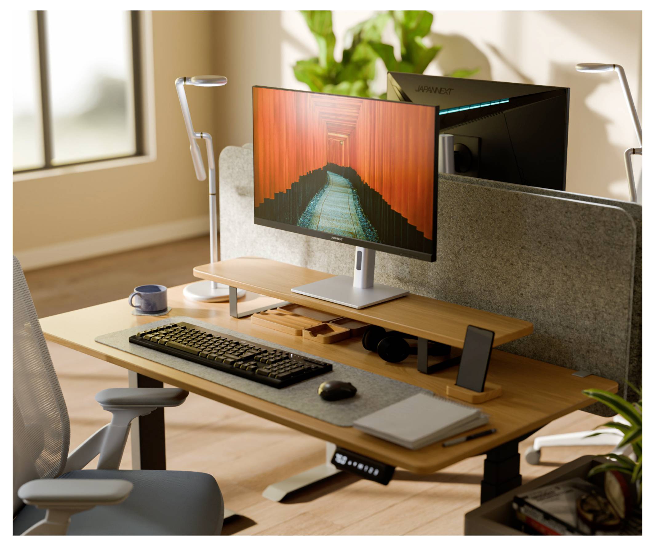 Modern thuiskantoor bureau met een groot scherm, toetsenbord, muis, luidsprekers, lampen en een kantoorstoel bij een zonnig raam.
