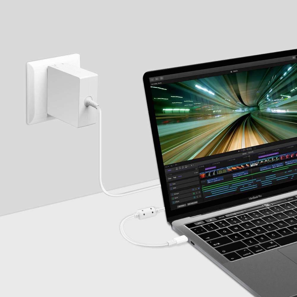 Laptop aangesloten op een wandlader, met videobewerkingssoftware open op het scherm en een stromsnoer aangesloten op het stopcontact.