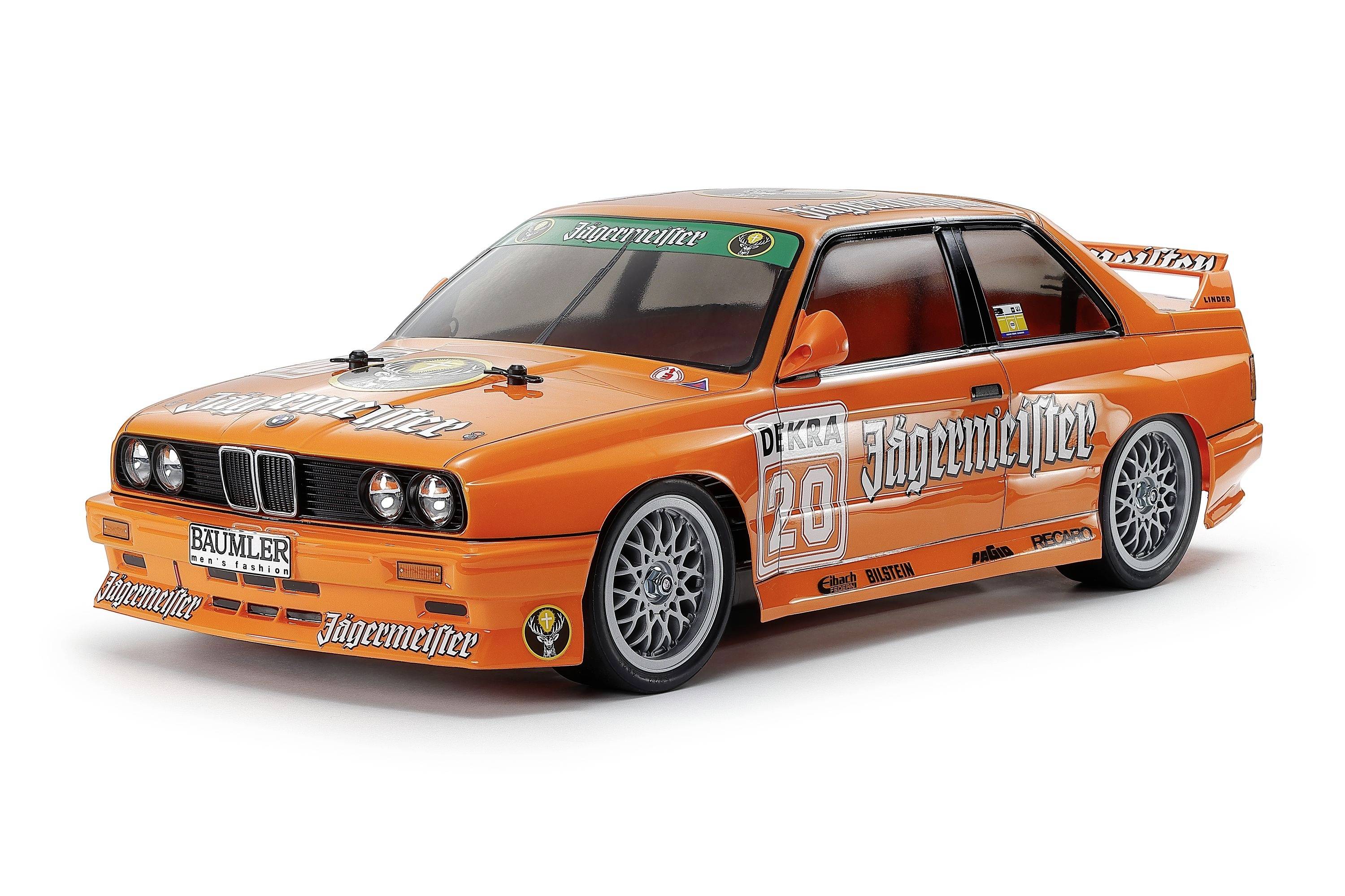 Oranje Jägermeister racewagen model met nummer 20, sponsordecals en grote achtervleugel op witte achtergrond.