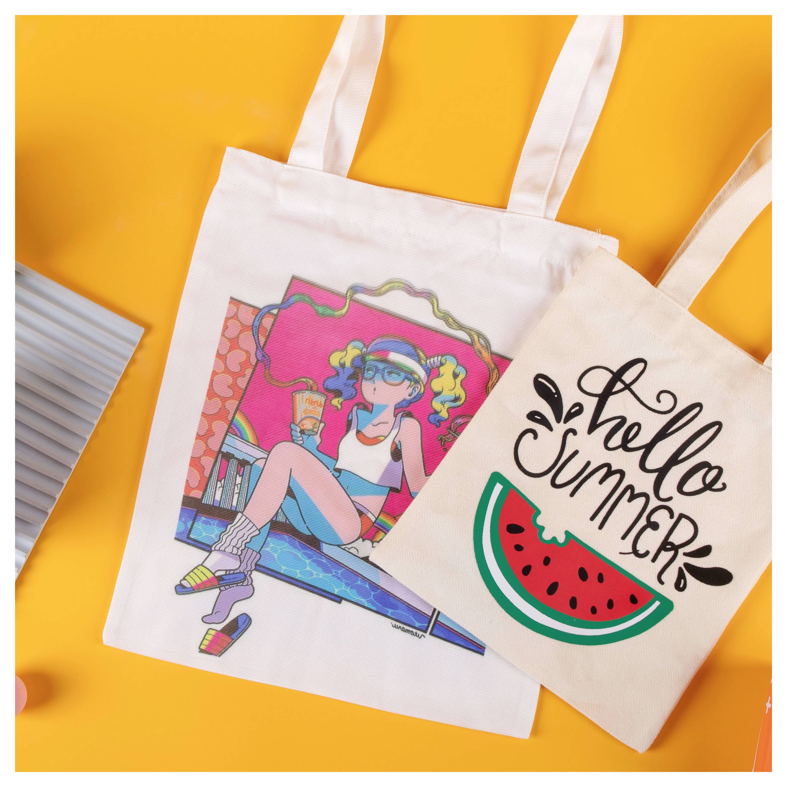 Twee canvas draagtas op een oranje achtergrond, een met een kleurrijke getekende vrouw en de ander met 'Hello Summer' en een watermeloenschijf.