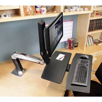 Een computerarbeidsplaats met een verstelbare monitorarm, toetsenbord en muis op een bureau in een goed georganiseerd kantoor.