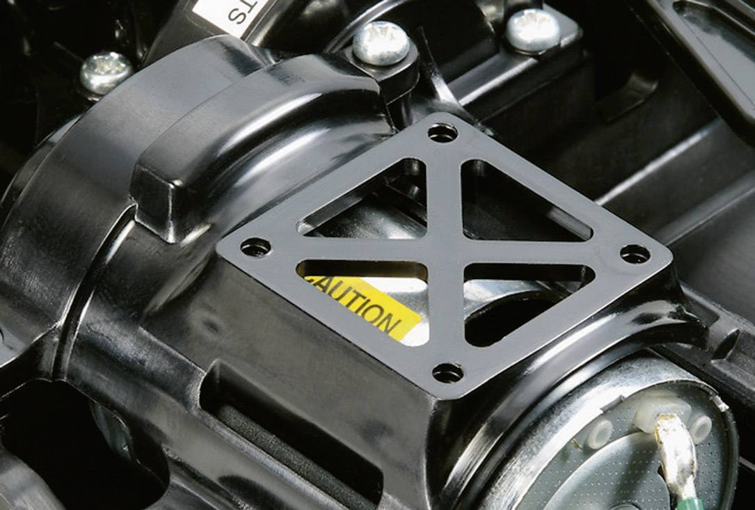 Close-up van een rechthoekige metalen beugel met kruislings versterkte steunen op een industrieel apparaat, omringd door metalen onderdelen.