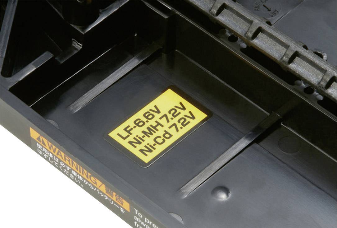 Een batterijvak met een gele sticker die de compatibele batterijsoorten aangeeft: 'LF 6.6V', 'Ni-MH 7.2V', 'Ni-Cd 7.2V'.