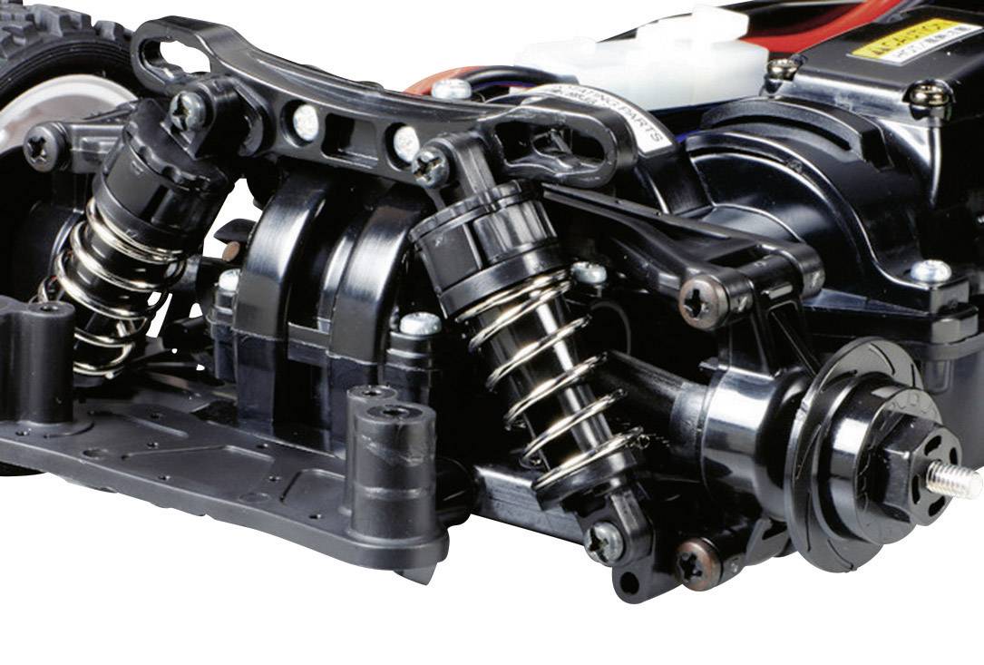 Close-up van de onderkant van een afstandsbediend auto-chassis met ophanging en schokdempers, toont technische details en mechanische componenten.