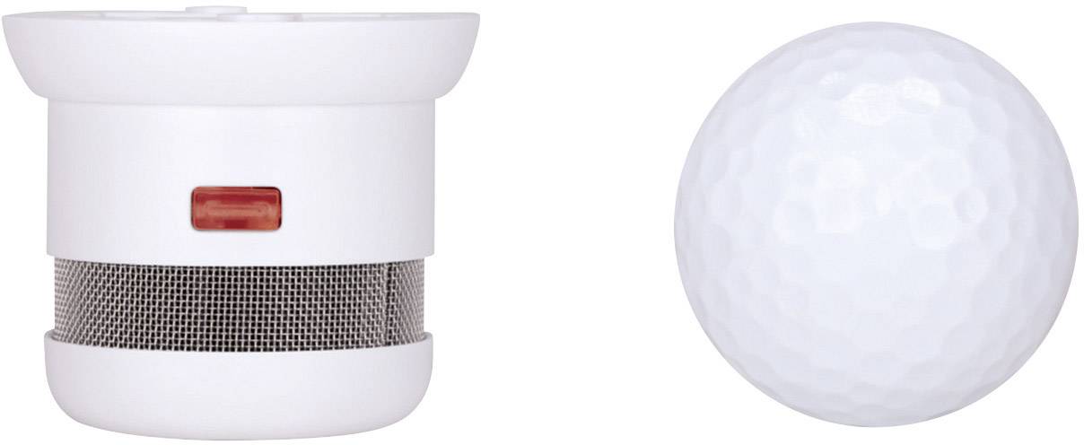 'Kleinere, rondere rookmelder naast een golfbal voor groottevergelijking. Rookmelder met rode knop en rooster, vergelijkbare diameter als een golfbal.'