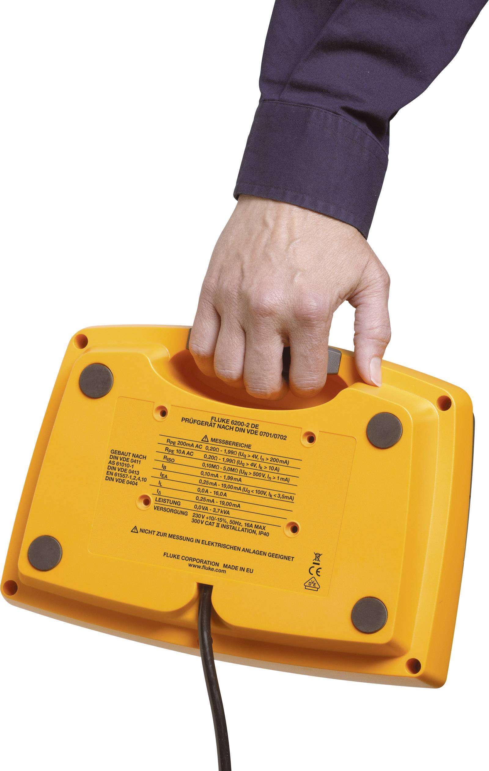 Een hand houdt een oranje elektronisch apparaat vast met een zwart kabel en tekst aan de onderkant.