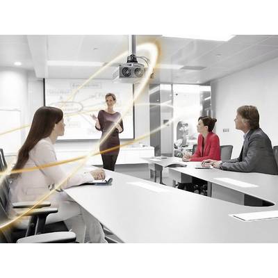 Een vrouw geeft een presentatie voor drie personen in een moderne vergaderzaal. Een projector hangt aan het plafond.