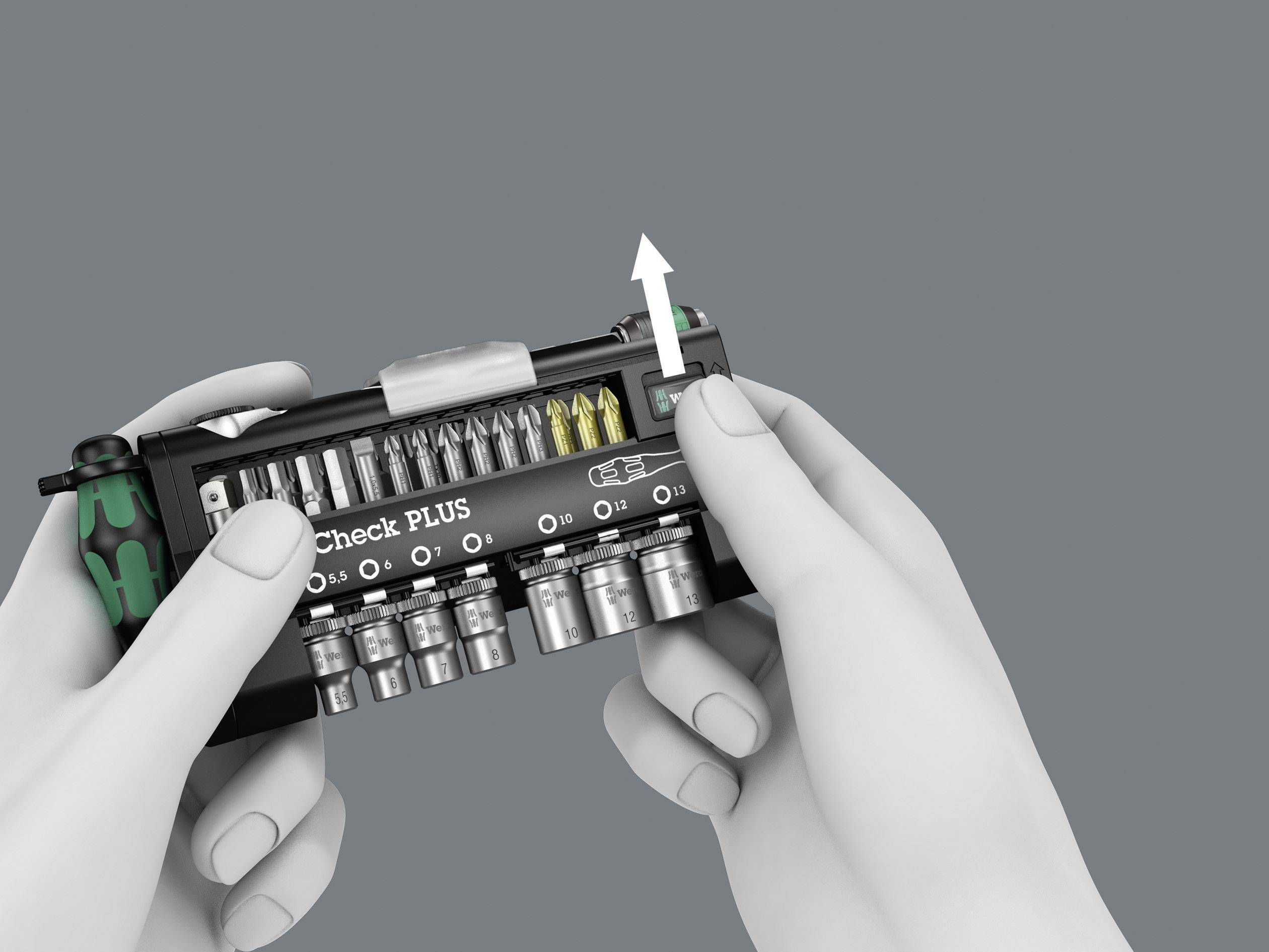 Handen houden een gereedschapsset met meerdere opzetstukken vast. Een pijl wijst naar de rechterbovenhoek en benadrukt een knop.