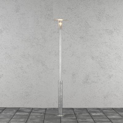 Een eenvoudige, zilverkleurige staande lamp met een cilindrische voet en een glazen lampenkap staat op een grijze betegelde vloer.