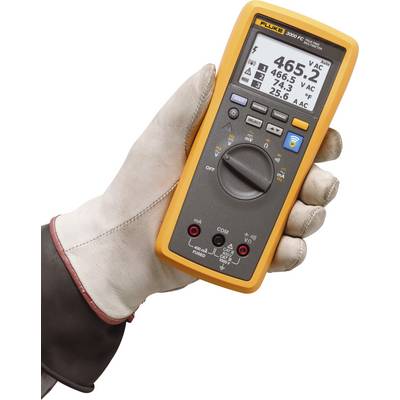 Een hand houdt een digitale multimeter vast die spanning en temperatuur aangeeft. Waarden op het display: 465,2 V AC, 25,6 °C.