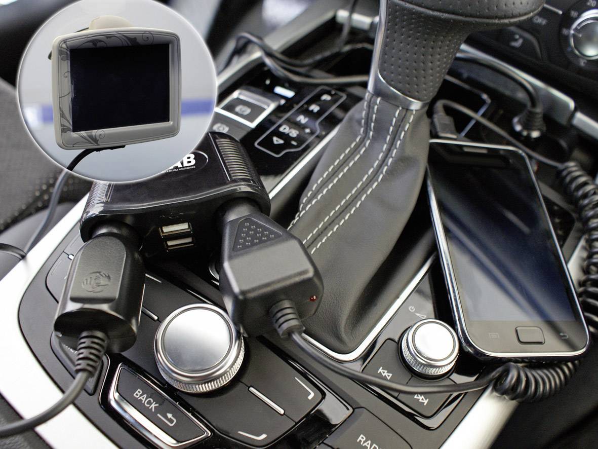 'Smartphone wordt opgeladen in een auto, naast de versnellingspook. Een GPS-apparaat is zichtbaar in de kleine weergave.'