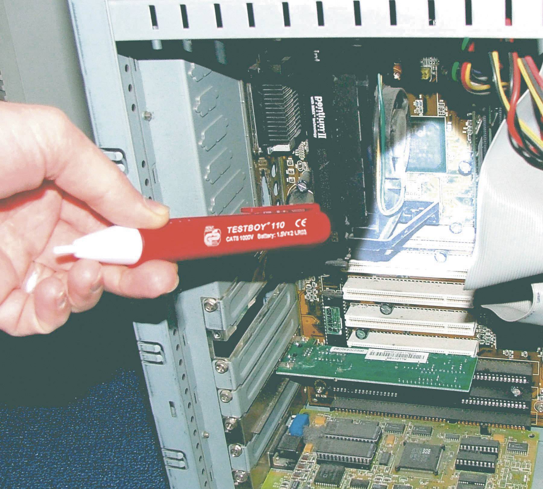 Een persoon controleert de kabelverbinding in de computerbehuizing op elektrische stroom met een spanningzoeker. Componenten en kabels zijn zichtbaar.
