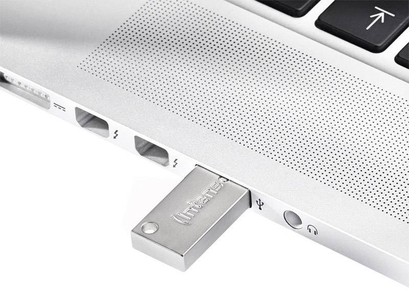 Een USB-stick steekt in een laptop. De stick bevindt zich naast een koptelefoonaansluiting en twee Thunderbolt-poorten.