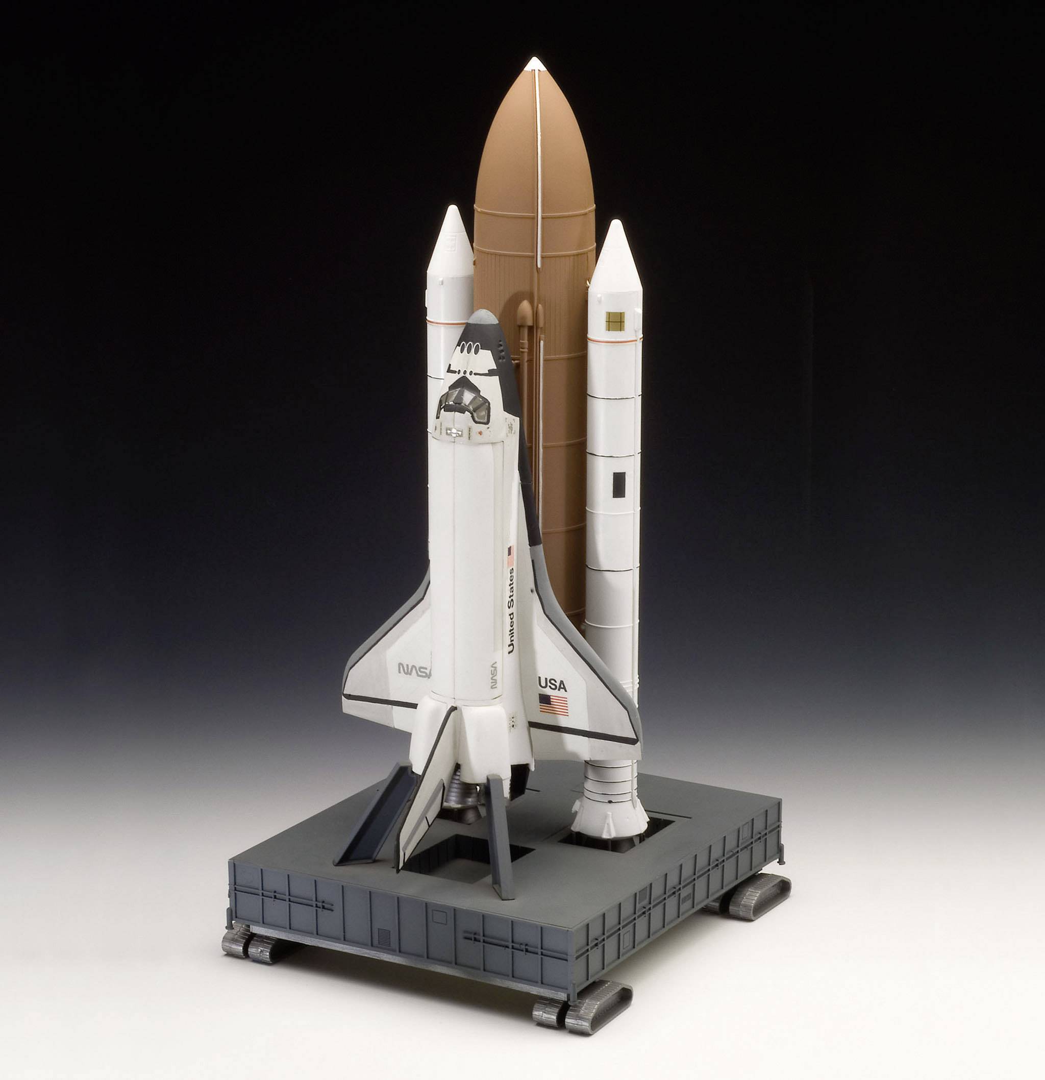 Een Space Shuttle-model op een basis die de lancering van een shuttle toont met twee zijdelingse vaste-brandstofraketten en een externe tank.