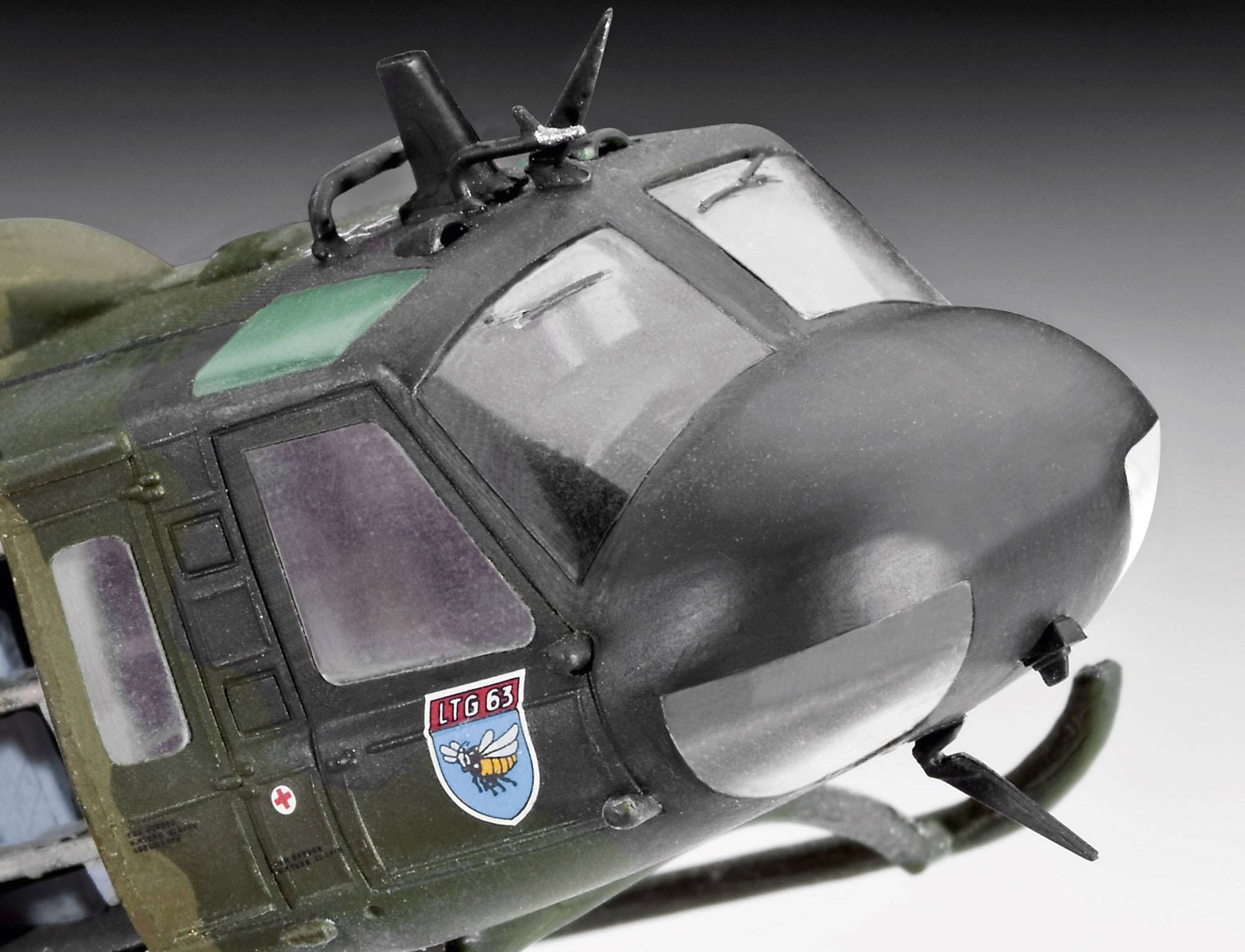 Close-up van een militaire helikopter met cockpit, 'LTG 63'-embleem en gedetailleerde ramen op de voorgrond.
