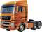 Een grote, oranje vrachtwagen zonder aanhanger, gezien van opzij, staat op een witte ondergrond.
