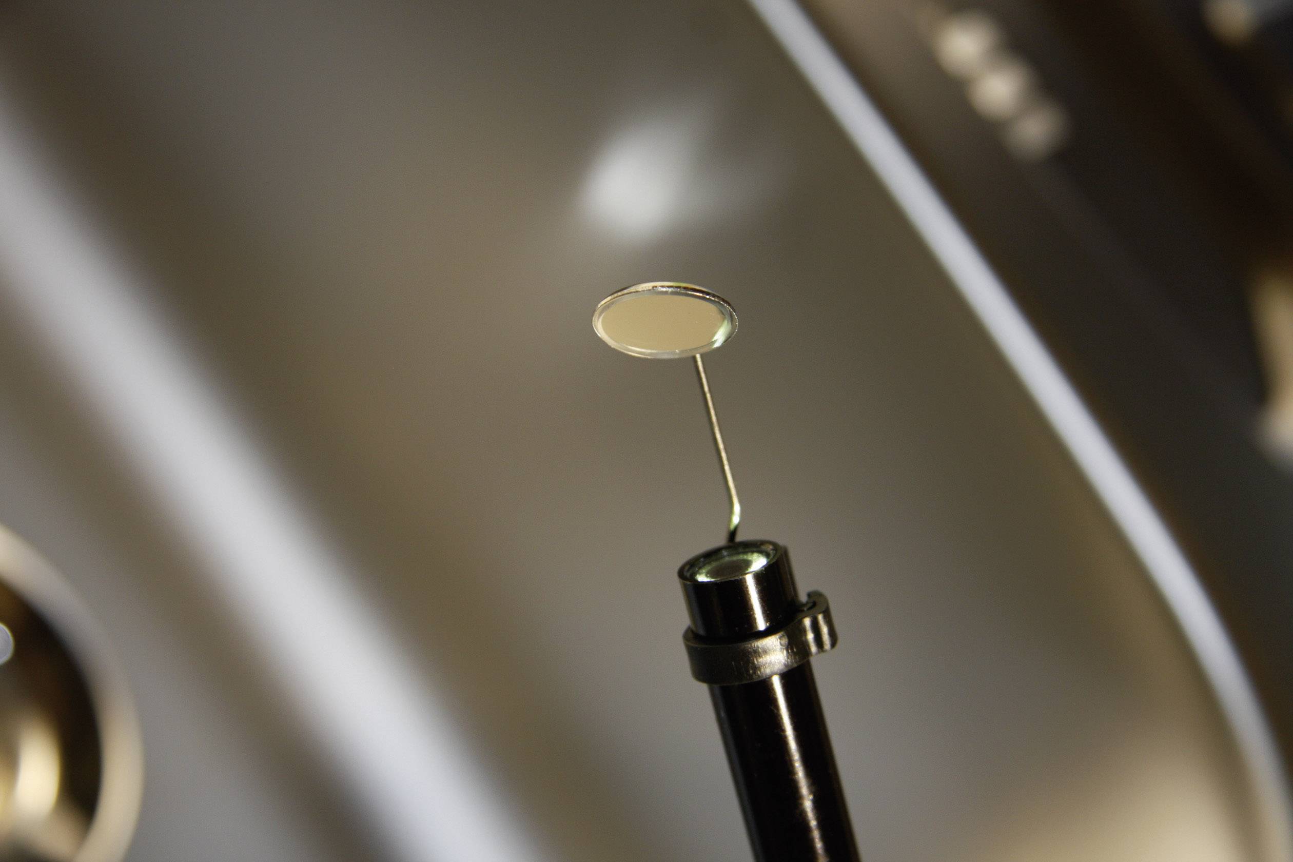 Tandenspiegel met metalen handvat in een tandartspraktijk tegen een onscherpe achtergrond.