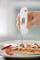 Een hand houdt een digitale thermometer in een pizzapunt. Het display toont 72,6 graden Celsius.