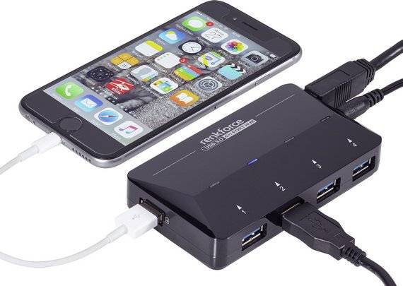 Een smartphone is verbonden met een USB-hub die meerdere USB-poorten aanbiedt. De smartphone wordt opgeladen.