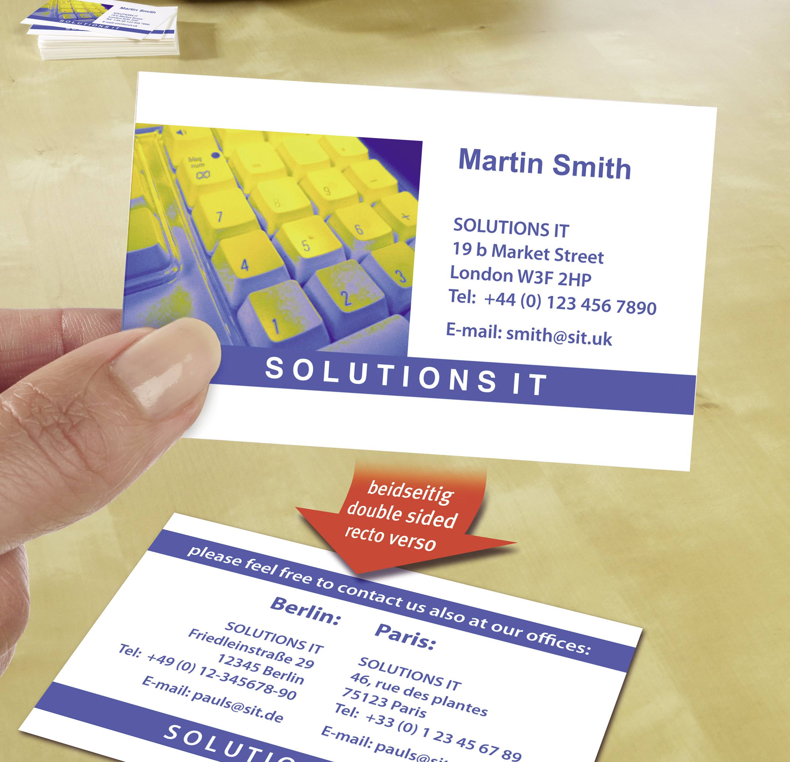 Visitekaartje van 'Martin Smith', SOLUTIONS IT, Londen. Bevat adres, telefoonnummers en e-mailadres. Achtergrond toont toetsenbord.