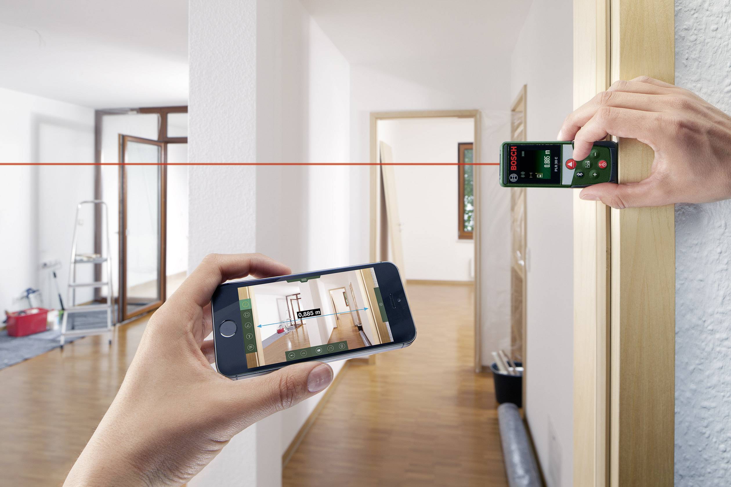 Een persoon meet een ruimte met een laserafstandsmeter en controleert het resultaat op een smartphone.