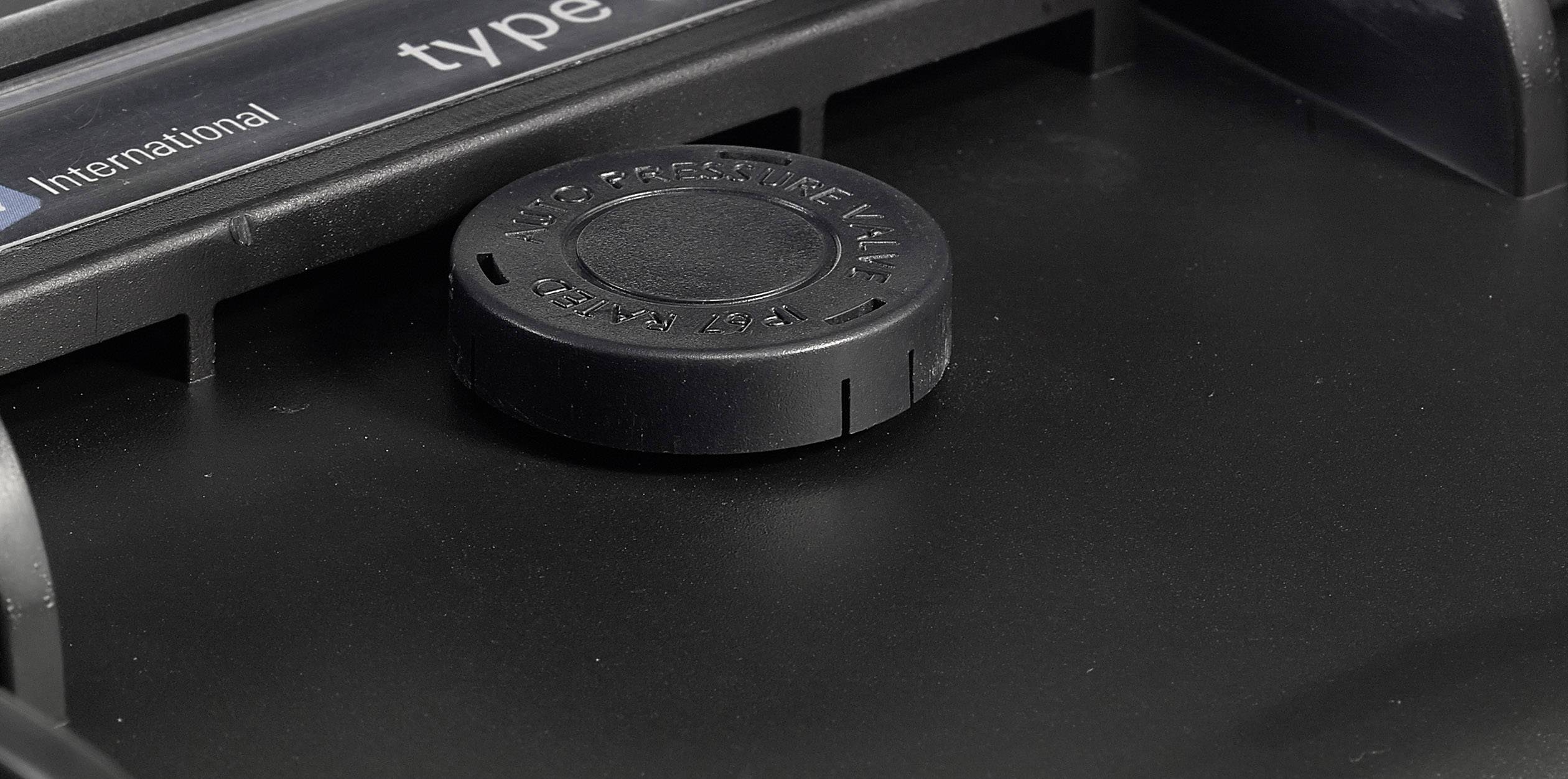 Zwart kunststof onderdeel close-up, met een centraal geplaatste ronde afdekking.