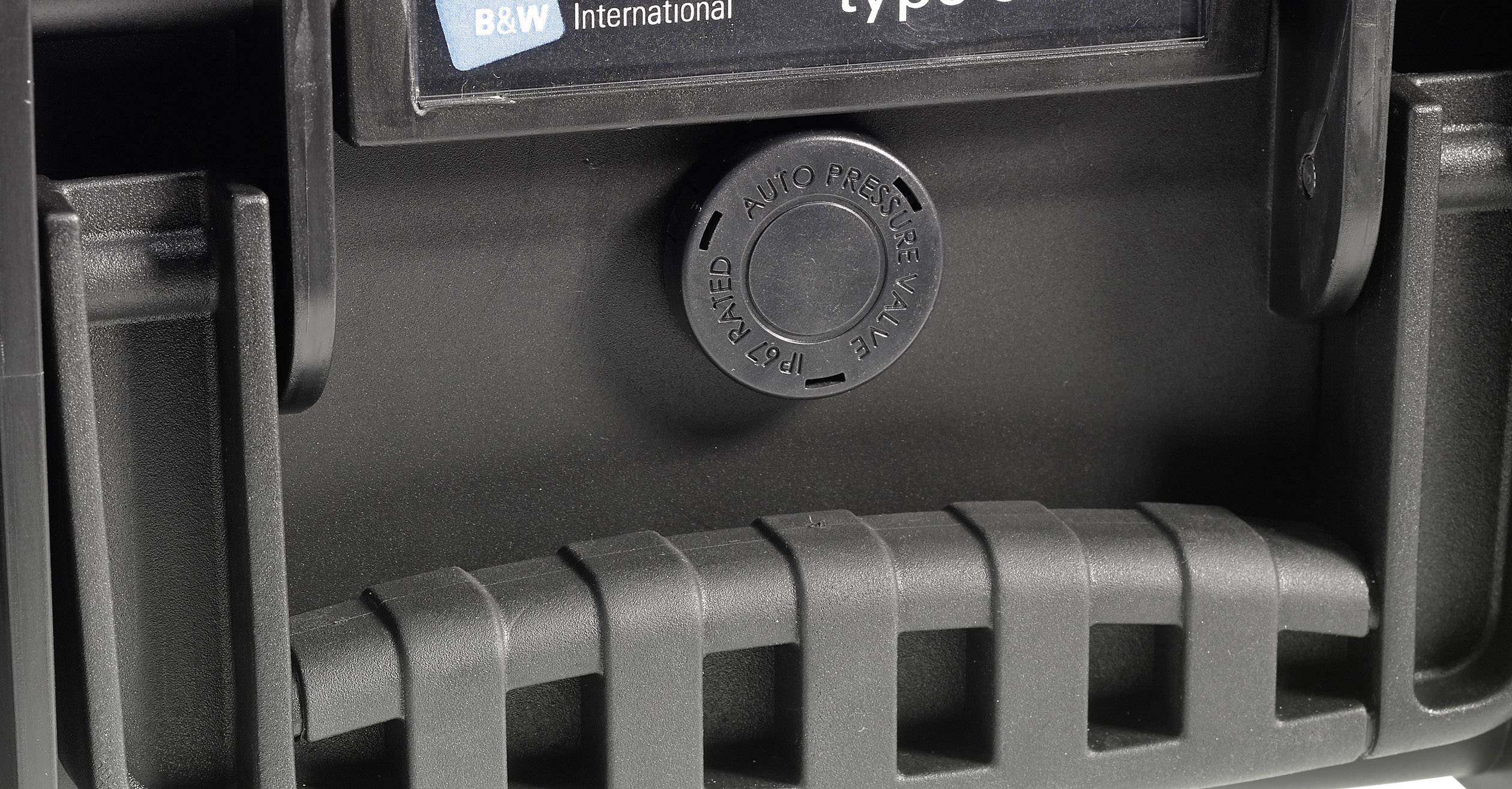 'Close-up van een zwarte kunststof handgreep met gemarkeerde automatische ontluchting en het logo van B&W International op de achtergrond.'