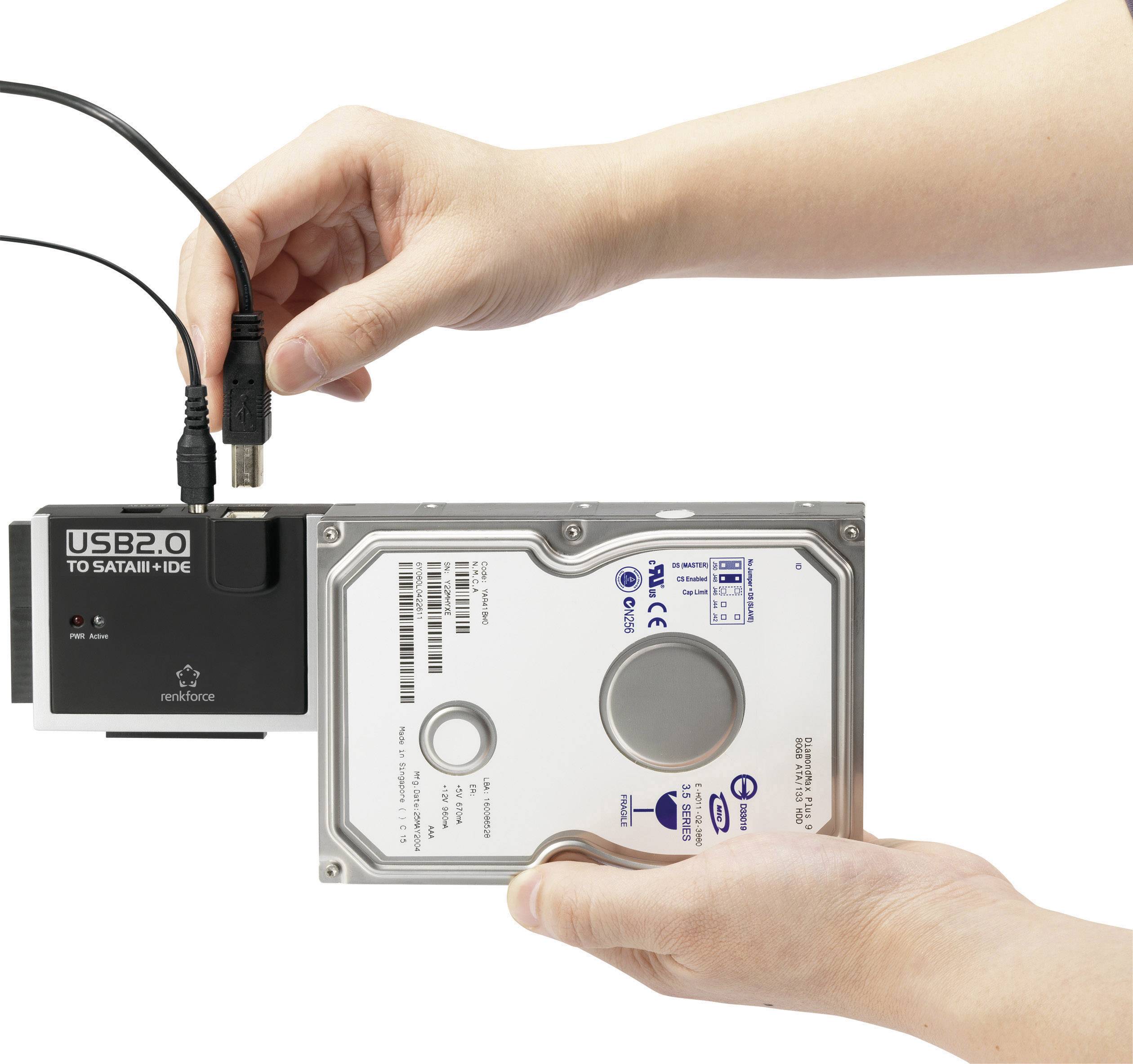 Een persoon verbindt een harde schijf met een adapterkabel voor de USB 2.0-aansluiting naar SATA/IDE.