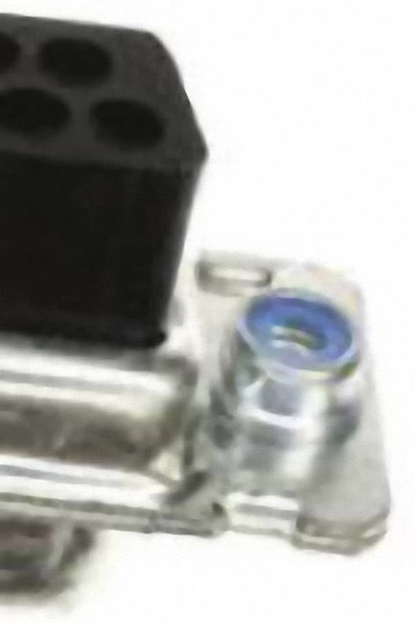 Close-up van een mechanisch onderdeel met een metalen behuizing en een zwart hoekelement.