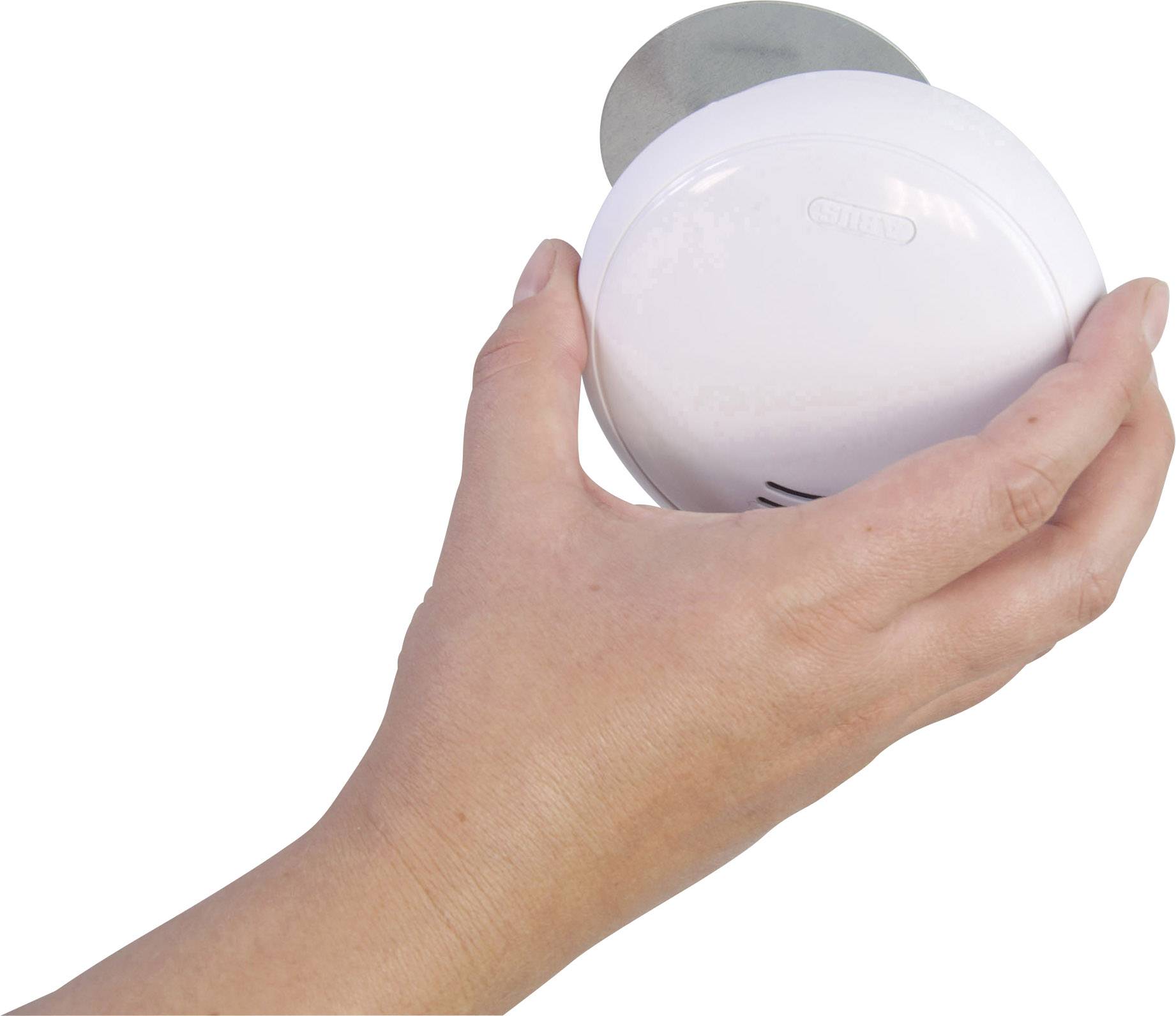 Hand houdt een rond, wit voorwerp met een gladde oppervlakte vast. Mogelijk een technisch apparaat of huishoudelijk voorwerp.