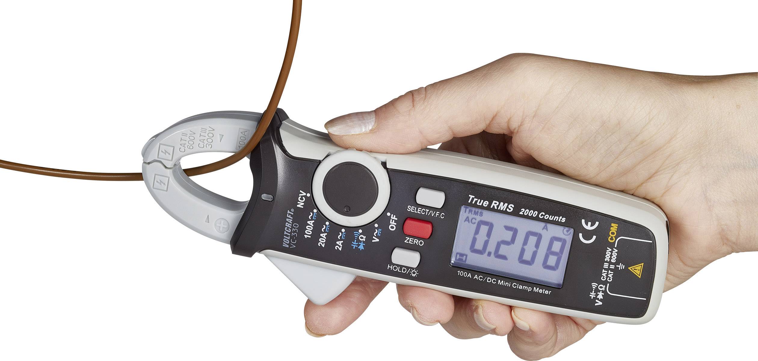 Hand houdt een digitale stroomtester vast met een display waarop '0,208' wordt weergegeven. Een kabel wordt door de klemmen van het apparaat vastgehouden.