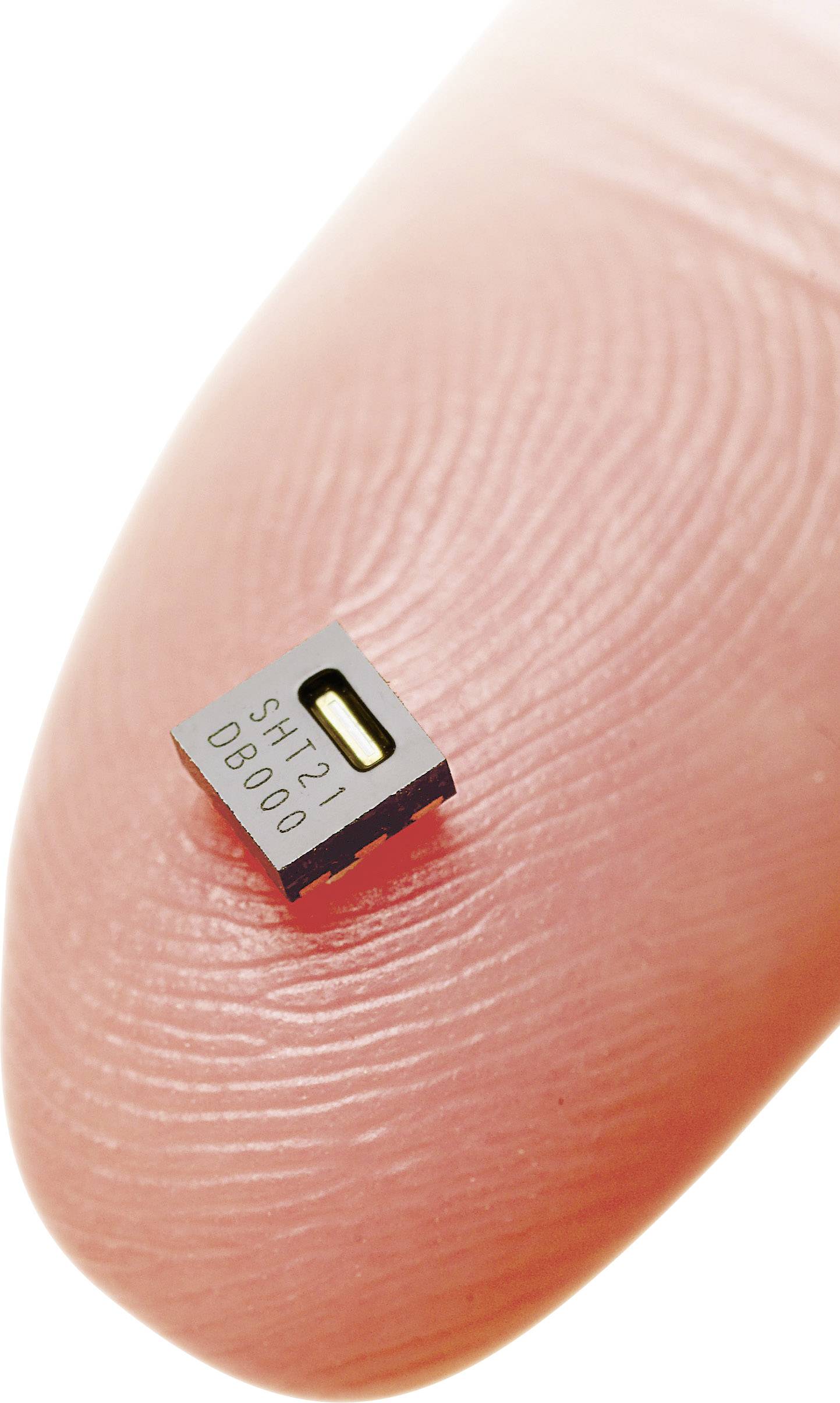 Een minuscule, vierkante sensorchip met het opschrift 'SHT21' rust op een vingertop en toont de kleine afmetingen van de chip.