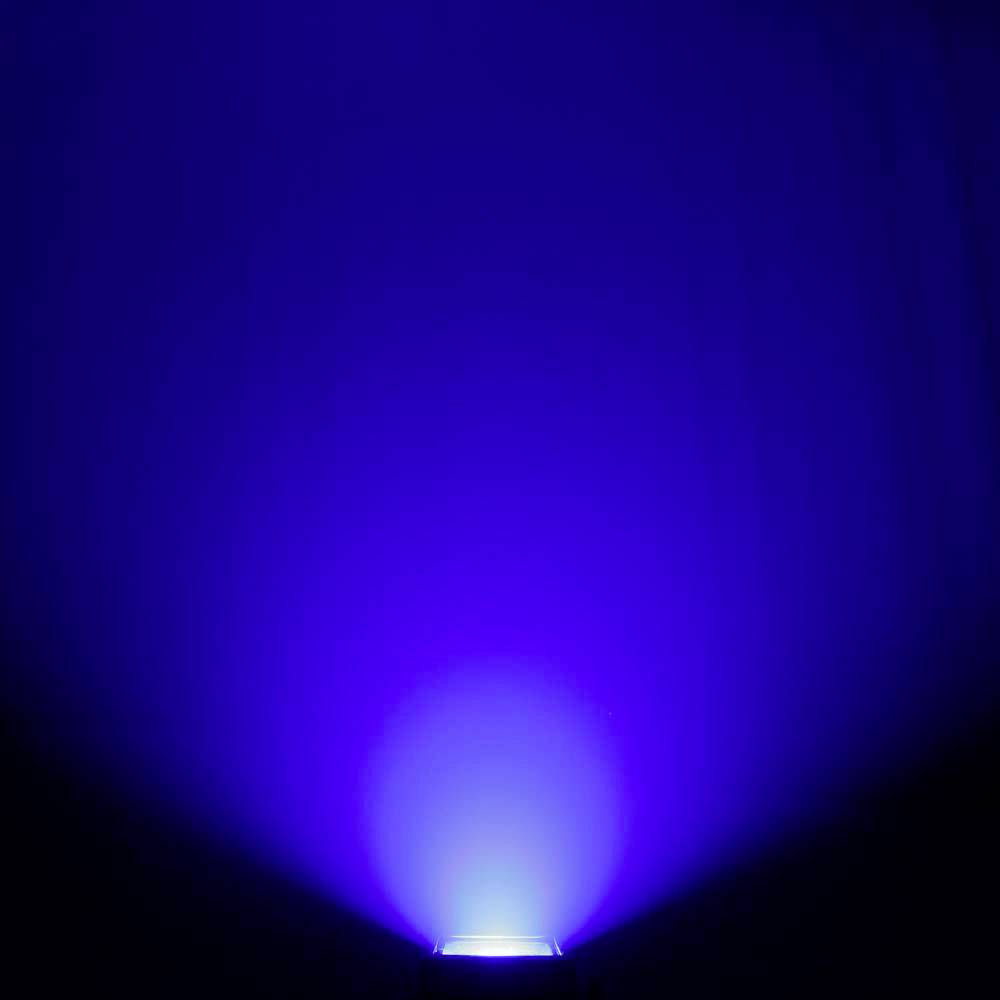 Een blauwe lichtstraal schijnt van onderen en creëert een oplichtend effect in het donker.