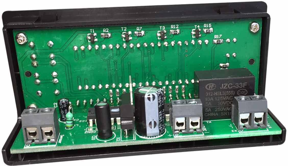 Elektronische schakeling met meerdere componenten op een groene printplaat, waaronder condensatoren, relais en aansluitingen.