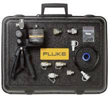 Gereedschapskoffer met 'Fluke'-logo, bevat een meetapparaat, verschillende adapters en kabels. Geschikt voor meetechniek en kalibratie.