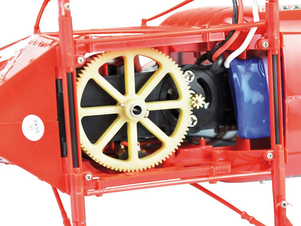 Rood modelvliegtuig met zicht op intern tandwiel en motor. Het hoofdtandwiel is geel, omgeven door kabels en andere onderdelen.