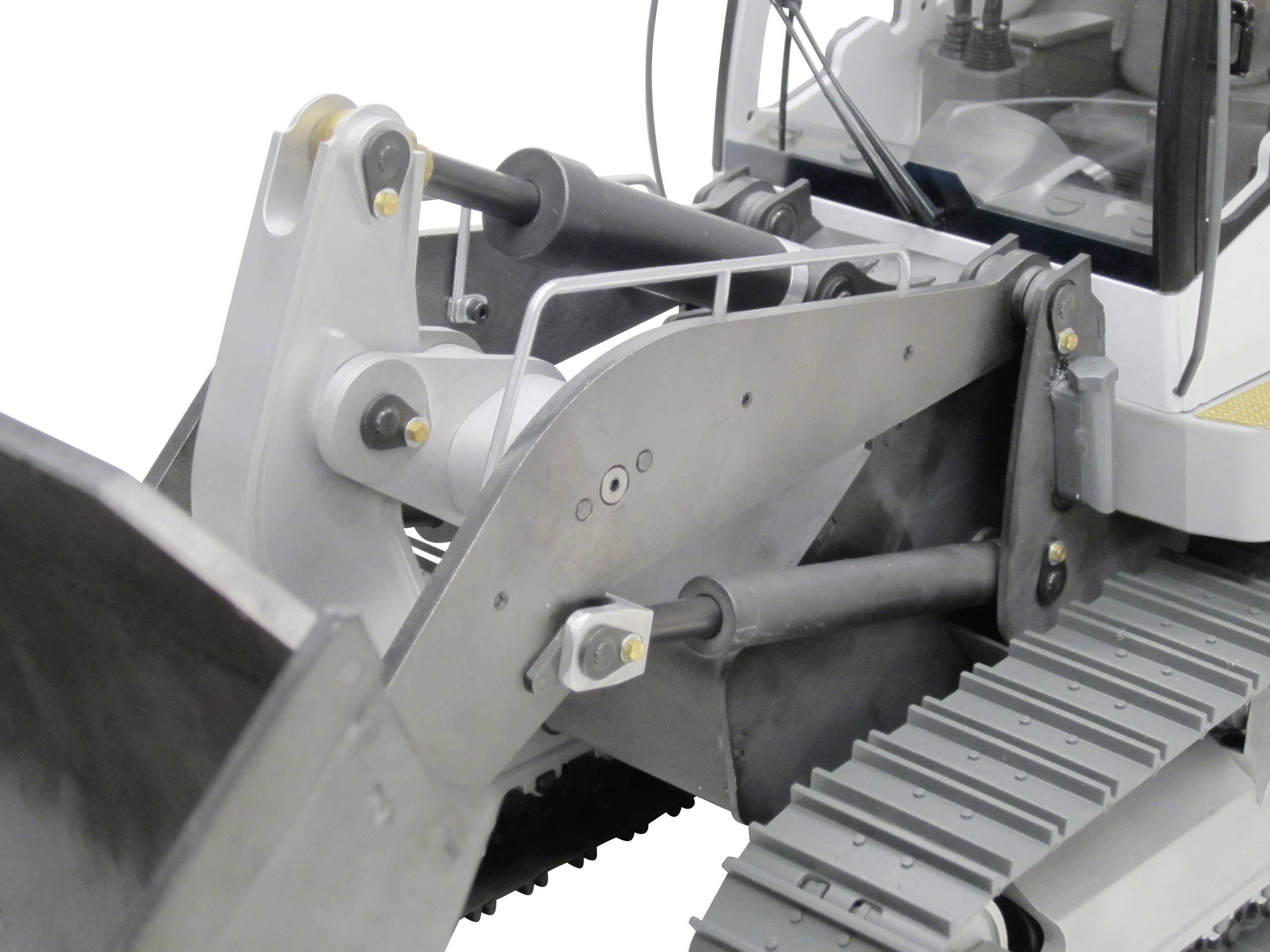 Een detail van een bouwvoertuig met een schop, hydraulische armen en aandrijving op rupsbanden. De machine lijkt te worden ingezet voor grondverzetswerkzaamheden.