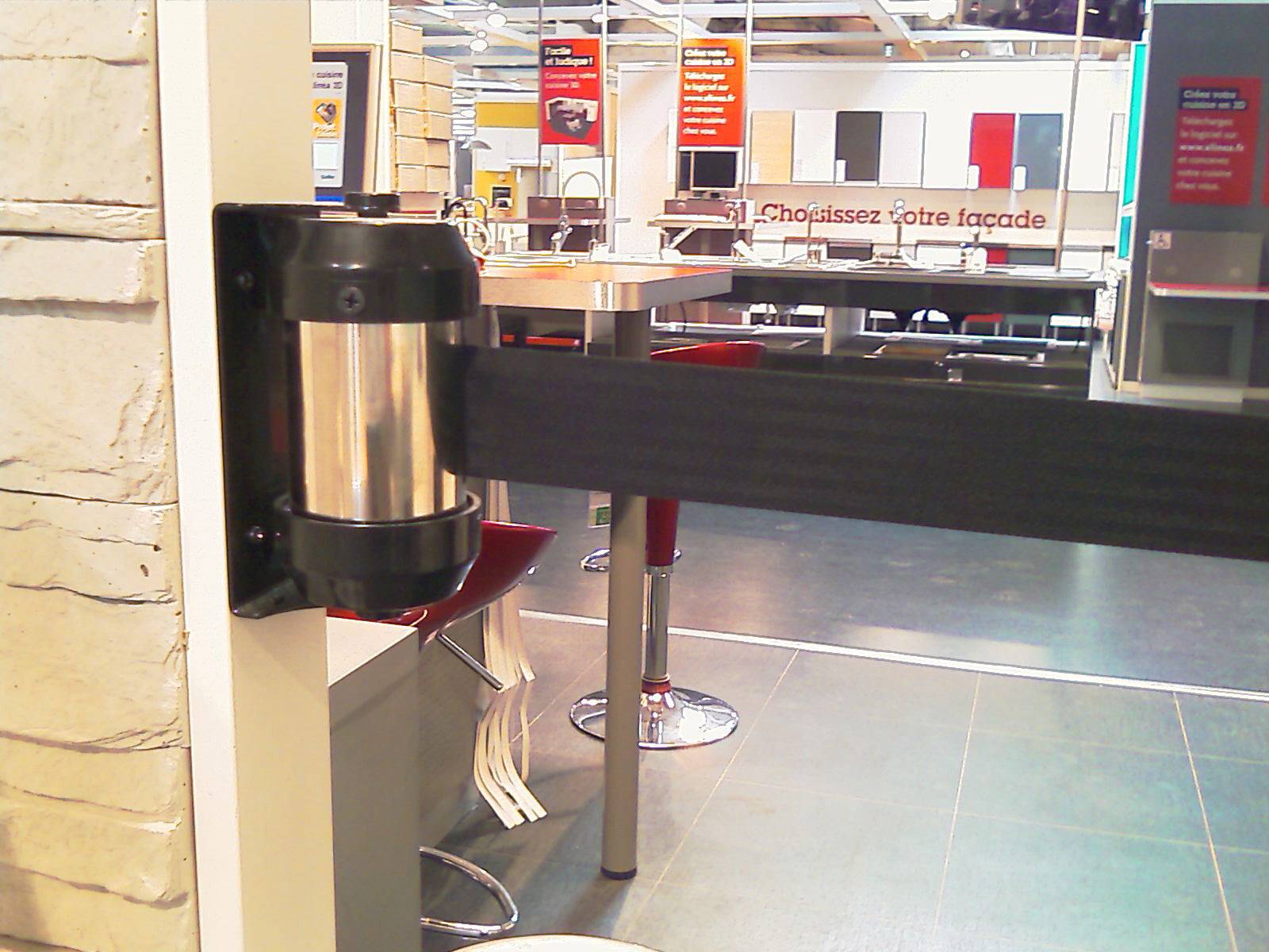 Een zwart veiligheidsband met metalen bevestiging voorkomt de doorgang naar een bepaald gebied in een winkel of café.