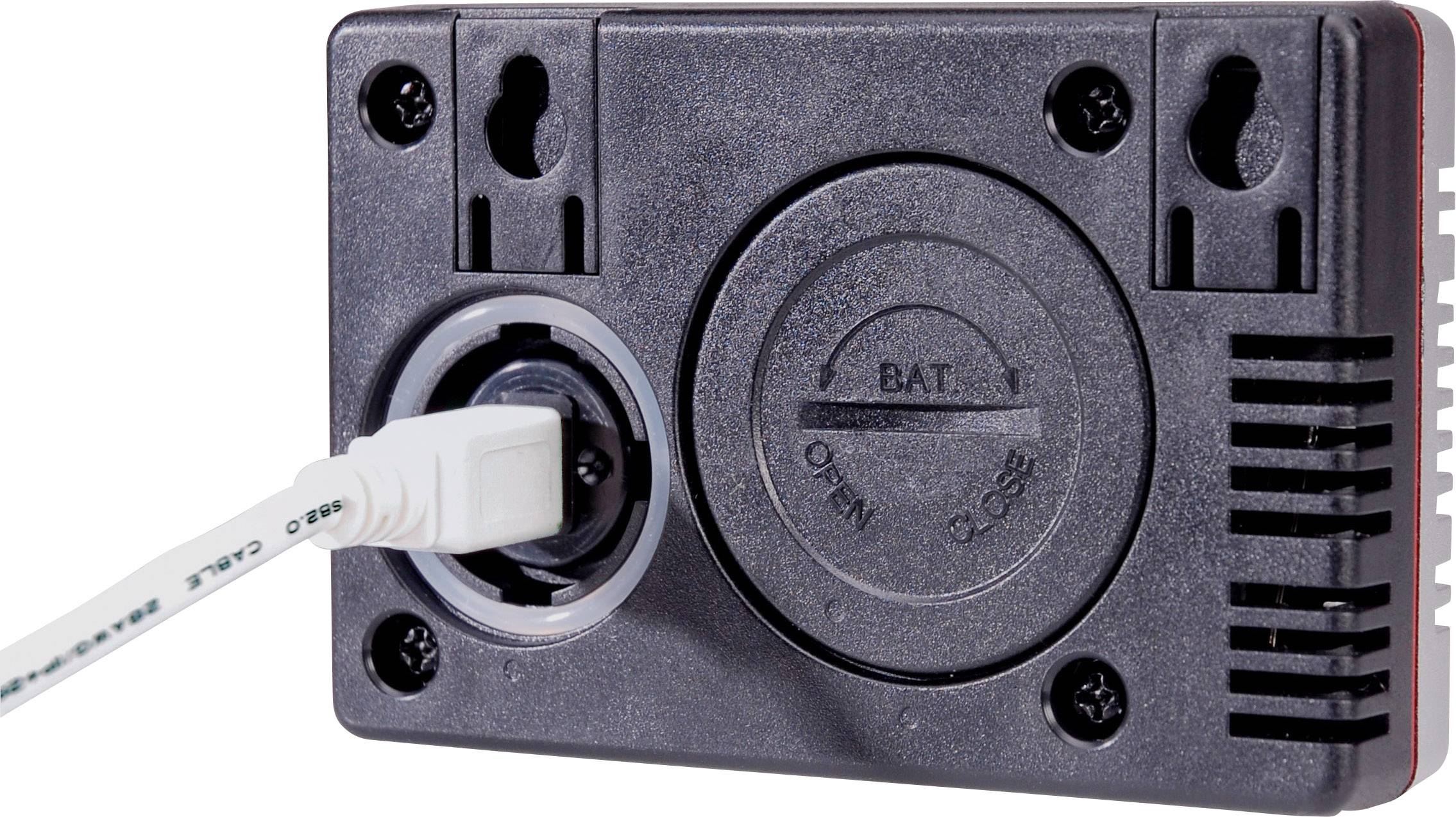 Een zwart elektrisch apparaat met een aangesloten wit snoer. Er is een ronde batterijdeksel met de markeringen 'Open' en 'Close'.