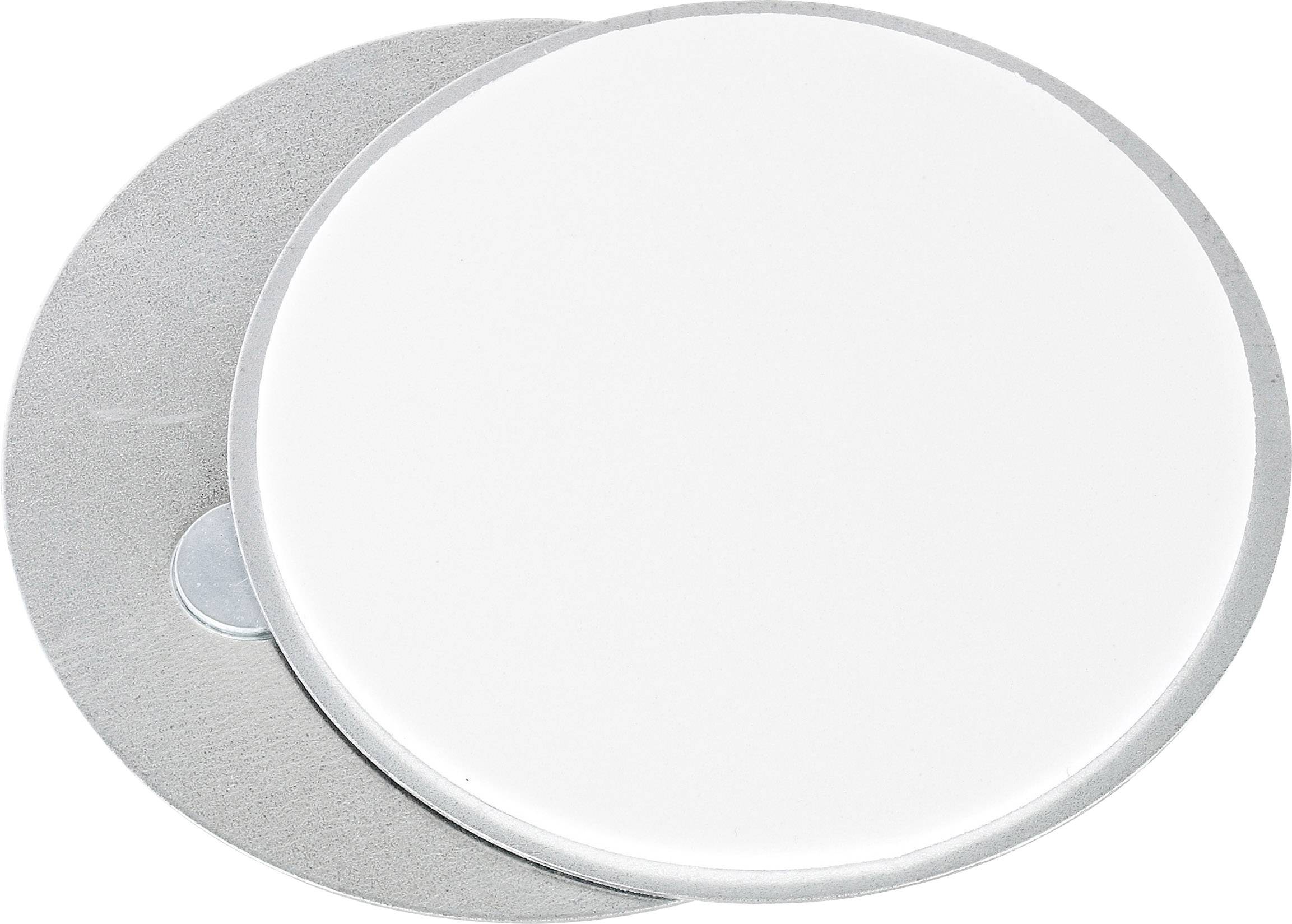 Twee op elkaar liggende ronde schijven, een wit en glad, de andere metallisch. Ze vormen een contrast van kleur en textuur.